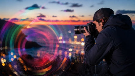 Photographer using creative camera movement to capture colorful light trails at twilight. 