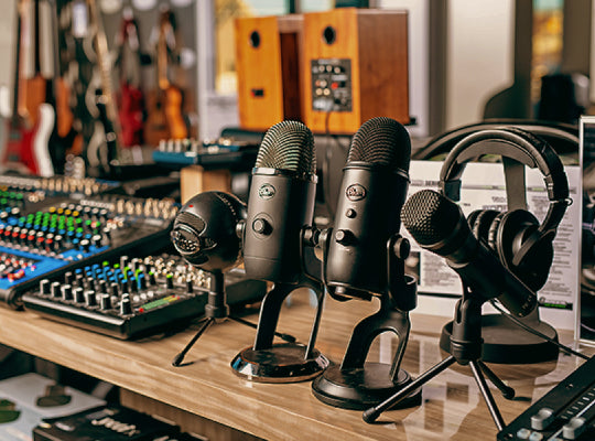 Three microphones on stands with audio equipment in the background, showing the capabilities of focus camera b2b & b2g