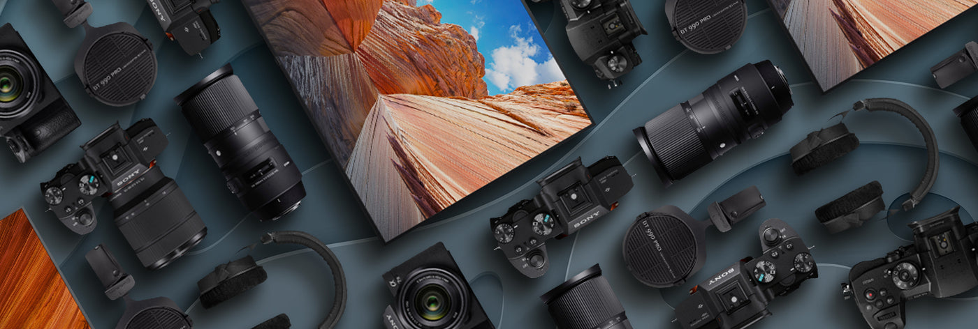 Collection of camera equipment on a textured surface with scenic prints.